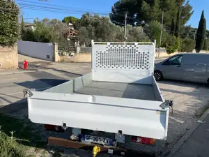 Benne basculante du Renault Master vue de l'arrière, ridelle rabattue et grille de protection de cabine